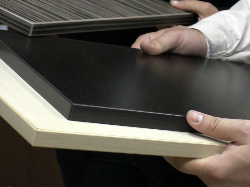 čovek drži par materijala od drveta u rukama i bira odgovarajući za svoj nameštaj